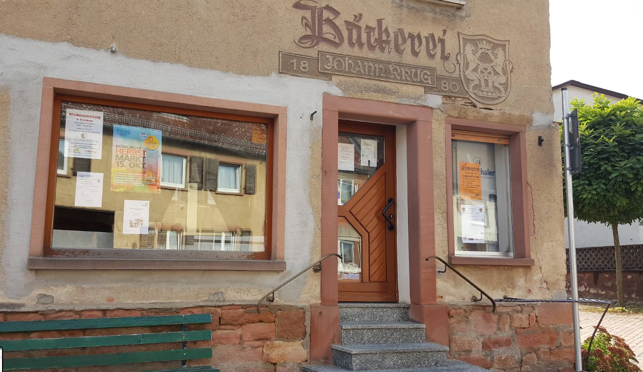 Ladenfront der Bäckerei Krug mit dem in Sandstein gemeißelten Schriftzug „Bäckerei Johann Krug“ und der Jahreszahl 1880